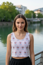 Woman wearing a patterned top standing by a waterfront with trees and buildings in the background