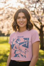 Woman wearing a pink t-shirt with a graphic design of a person walking a dog, standing in a park with cherry blossom trees.