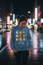 Person wearing a blue sweatshirt with colorful designs on a city street at night.