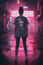 Person wearing a t-shirt with a flamingo design in a neon-lit urban setting