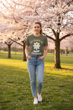 Woman wearing a t-shirt with a graphic design in a park with cherry blossom trees.