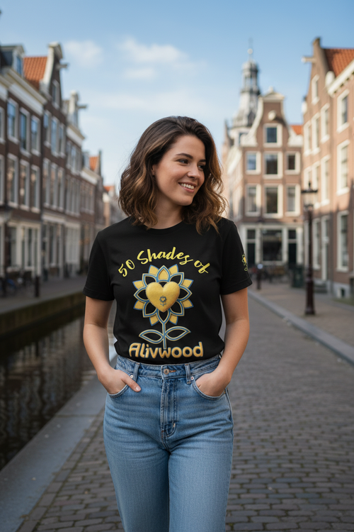 Woman wearing a black t-shirt with a sunflower design and text, standing on a street with historic buildings.