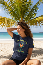 Woman wearing a blue t-shirt with a logo on a beach with palm trees and ocean in the background